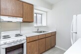 Located at 1703 Cresthill Ave in Royal Oak, Michigan, this single-floor home offers a clean, functional layout designed for comfortable everyday living. The kitchen is a standout feature, outfitted with warm oak cabinetry spanning both upper and lower sections, generous white countertop workspace, light vinyl flooring, and essential appliances including a range and refrigerator. Under-cabinet lighting adds a practical touch, while a sink with a window view enhances the bright, airy feel of the space. The bedrooms are carpeted in neutral tones and bathed in natural light courtesy of large windows dressed with vertical and horizontal blinds. Each bedroom includes closet storage, with one featuring a set of louvered bifold doors. The bathroom is efficiently arranged with an oak vanity, a white countertop with an integrated sink, tile flooring, and a glass-enclosed shower-tub combination. The overall aesthetic throughout the home is light and neutral, with white walls, clean trim, and consistent finishes that create a cohesive and move-in-ready environment. The doll-house view reveals a compact yet well-organized floor plan that maximizes the use of available space across all rooms.