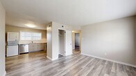 Located at 2330 Hampstead Ave in Richmond, Virginia, this two-bedroom, one-bathroom residence offers a well-organized, single-floor layout finished with contemporary updates throughout. Light-toned luxury vinyl plank flooring runs continuously across every room, giving the space a cohesive, clean aesthetic complemented by neutral gray-beige walls and bright white trim.

The kitchen is a functional highlight, featuring gray shaker-style cabinetry, white subway tile backsplash, and a full suite of stainless steel appliances including a gas range, refrigerator, and dishwasher. A window above the sink brings in natural light, and a stacked washer and dryer unit with additional open shelving adds convenient in-unit laundry. The kitchen flows openly toward the main living area, which includes a built-in closet for added storage.

Both bedrooms are well-proportioned and bright. The primary bedroom features a large window with views of the surrounding neighborhood, while the second bedroom includes a dedicated closet with a rod and shelf. The bathroom is finished with white tiled walls, a tub-shower combination with modern chrome fixtures, and a window for natural ventilation.

A hallway connects the main living spaces efficiently. Throughout the residence, the clean, updated finishes and practical layout make this a well-appointed home in Richmond's established Hampstead neighborhood.