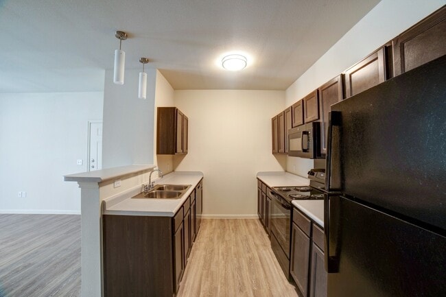 Cocina con barra de desayuno - Grand Station Apartment Homes