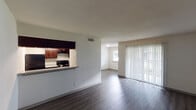 This single-story, one-bedroom, one-bathroom unit in Houston, Texas offers a practical and well-organized layout designed for efficient everyday living. The open living area features wood-style laminate flooring and neutral wall tones that create a clean, cohesive atmosphere throughout. A pass-through counter connects the living space to the kitchen, enhancing the sense of openness while maintaining a defined separation between areas. A sliding glass door fitted with vertical blinds allows natural light to enter and provides access to the outdoors.

The kitchen is equipped with dark espresso cabinetry, granite-style countertops, black appliances including an electric range and refrigerator, and a double sink, offering ample storage and functional prep space along a galley-style corridor with light wood-style flooring.

The bedroom features soft carpeting, a window with blinds that brings in natural light, and access to the bathroom, which includes a vanity with granite-style countertops, dark wood cabinetry, a framed mirror, and a separate water closet. A closet adjacent to the bathroom provides additional storage. Textured ceilings are present throughout the unit, contributing to its traditional residential character.