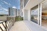 Located at 10476 NW 82nd St in Doral, Florida, this well-appointed one-bedroom, one-bathroom residence offers a thoughtfully designed layout across a single floor. Light-toned hardwood-style flooring runs throughout the interior, lending a clean, cohesive aesthetic to each room.

The open-concept living and dining area is bright and airy, benefiting from large floor-to-ceiling sliding glass doors that connect seamlessly to a private balcony. The balcony features metal railing and offers open views of the surrounding Doral skyline and greenery, making it an ideal space for relaxing outdoors.

The kitchen is outfitted with a modern design, combining white lower cabinetry with warm wood-toned upper cabinets and white quartz-style countertops. A full suite of stainless steel appliances — including a side-by-side refrigerator with ice maker, electric range, built-in microwave, and dishwasher — ensures full functionality. Track lighting above the kitchen adds a contemporary touch.

A dedicated laundry closet houses a stacked washer and dryer unit, providing in-unit convenience. The bedroom is a comfortable, well-lit space with a large window and two closets for ample storage. The entrance area and bathroom complete this efficiently planned residence, ideal for those seeking a modern, low-maintenance home in Doral.