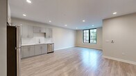 Located at 24 Gould Street in Reading, MA, this thoughtfully designed 2-bedroom, 2-bathroom residence offers a clean, contemporary aesthetic across a well-appointed single-floor layout. The open-concept kitchen and living area serves as the heart of the home, featuring light hardwood-style flooring, recessed lighting, and bold black-framed windows that invite natural light and outdoor views. The kitchen is outfitted with sleek gray cabinetry, white quartz countertops, a subway tile backsplash, and a full suite of stainless steel appliances including a refrigerator, range, microwave, and dishwasher. The spacious living area flows seamlessly from the kitchen, offering ample room for flexible furniture arrangements. Both bedrooms continue the light flooring and neutral palette, with the generously sized primary bedroom providing a comfortable and private retreat. Each of the two bathrooms is finished with light tile flooring, gray vanity cabinetry, and clean white fixtures, reflecting the same modern sensibility found throughout the residence. Two dedicated closets provide practical storage solutions. Recessed lighting and a consistent neutral color scheme create a bright, cohesive ambiance throughout this well-designed Reading home.