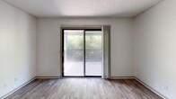 Located at 1521 Hickory Valley Rd in Chattanooga, TN, this well-appointed one-bedroom, one-bathroom unit offers a thoughtful layout across a single floor. The living room is a bright, welcoming space highlighted by wood-look flooring and a full-width sliding glass door that opens to a private balcony overlooking lush greenery, filling the room with natural light and outdoor views. The kitchen is a standout feature, showcasing white shaker cabinetry with sleek hardware, bold granite countertops, a classic white subway tile backsplash, and a full suite of stainless steel appliances including a refrigerator, dishwasher, range, and microwave. Wood-look flooring carries throughout the kitchen and hallway, lending a cohesive, modern aesthetic. The spacious primary bedroom is carpeted for comfort and features a ceiling fan with light, a window with outdoor views, and ample wall space. The bathroom continues the wood-look flooring and is finished with textured walls and a clean, functional design. A connecting hallway ties all rooms together efficiently. Neutral tones and clean finishes throughout give the space a fresh, move-in-ready feel ideal for comfortable everyday living.