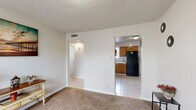 This single-floor, 2-bedroom, 1-bathroom home offers a practical and well-organized layout across a compact but functional footprint. The kitchen is equipped with warm oak cabinetry, tile countertops, a gas range, a double-basin sink, and tile backsplash, with a window allowing natural light to brighten the workspace. Adjacent to the kitchen is a dining area with light tile flooring, providing a clean and open space for everyday meals. The living room features soft carpet flooring, a textured ceiling, and a hallway leading to the private quarters of the home. Both bedrooms are carpeted and receive natural light through slatted blinds-covered windows. The primary bedroom is a comfortable size and includes a window view, while the second bedroom benefits from two windows, filling the room with abundant daylight. The shared bathroom includes a full tub-shower combo with floor-to-ceiling white tile surround and a window for ventilation. A connecting hallway ties the rooms together, creating a straightforward and easy-to-navigate floor plan. The overall palette is neutral throughout, with light walls and understated finishes that lend the home a clean, move-in-ready feel.