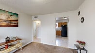 This single-floor, 2-bedroom, 1-bathroom home offers a practical and well-organized layout across a compact but functional footprint. The kitchen is equipped with warm oak cabinetry, tile countertops, a gas range, a double-basin sink, and tile backsplash, with a window allowing natural light to brighten the workspace. Adjacent to the kitchen is a dining area with light tile flooring, providing a clean and open space for everyday meals. The living room features soft carpet flooring, a textured ceiling, and a hallway leading to the private quarters of the home. Both bedrooms are carpeted and receive natural light through slatted blinds-covered windows. The primary bedroom is a comfortable size and includes a window view, while the second bedroom benefits from two windows, filling the room with abundant daylight. The shared bathroom includes a full tub-shower combo with floor-to-ceiling white tile surround and a window for ventilation. A connecting hallway ties the rooms together, creating a straightforward and easy-to-navigate floor plan. The overall palette is neutral throughout, with light walls and understated finishes that lend the home a clean, move-in-ready feel.