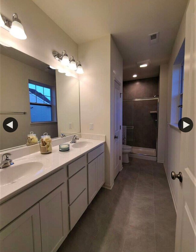 Baño principal de lujo con doble lavabo y azulejos - 401 Cadence Cir