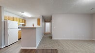 Located at 395 Jack Miller Blvd in Clarksville, Tennessee, this single-floor, three-bedroom, two-bathroom home offers a practical and comfortable layout. The kitchen is efficiently designed with warm oak cabinetry, white appliances including a range and dishwasher, a double stainless steel sink, and durable wood-style flooring. A peninsula counter provides a seamless transition into the dining area, which features rich hardwood-style flooring and an elegant gold chandelier as a focal point. The living room is carpeted and filled with natural light, highlighted by a set of French doors that open to the outdoors. Each of the three bedrooms is finished with soft carpet and neutral-toned walls, offering a calm and restful atmosphere. One bedroom includes a closet for added storage convenience. The two bathrooms are cleanly appointed, with one featuring an oak vanity, a lighted mirror, and wood-style flooring. A hallway with flanking closet doors leads to the bathroom, adding practical storage to the corridor. Textured ceilings are consistent throughout the home, contributing to its classic residential character. The layout flows logically from the common living areas to the private bedrooms, making efficient use of the overall footprint.