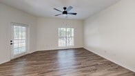 Located at 1600 N Ninth St in Midlothian, TX, this well-appointed one-bedroom, two-bathroom residence offers a thoughtfully designed single-floor layout. The open-concept kitchen and living area serve as the heart of the home, featuring light gray shaker-style cabinetry, quartz countertops, a double-basin sink with a matte black faucet, a skylight, and a full suite of stainless steel appliances including a refrigerator, electric range, and built-in microwave. Wood-style luxury vinyl plank flooring flows throughout the main living areas, complemented by crisp white walls and clean panel doors with matte black hardware. The living room is bright and airy, with a ceiling fan, natural light from a window with blinds, and a private entry door. The bedroom offers plush carpeting, a ceiling fan, and a large window framing outdoor greenery, creating a calm retreat. A dedicated closet provides convenient storage. Both bathrooms are clean and functional, featuring wood-look flooring, wall-mounted cabinetry, and modern fixtures. A hallway connects the living spaces with ease, maintaining a cohesive and efficient flow throughout the residence. This unit delivers a modern, move-in-ready living experience in a comfortable Midlothian community.