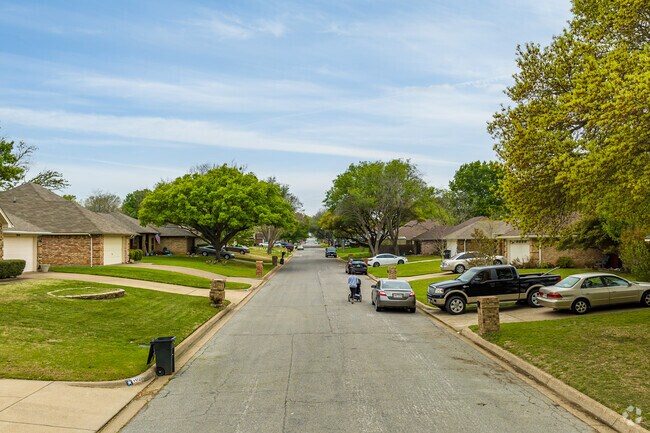 The streets of North Richland Hills are lined with tall trees and green grass.