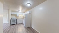 This single-floor unit located at 5580 Bridgetown Rd in Cincinnati, Ohio, offers a clean, neutral interior designed for comfortable everyday living. The layout flows from a welcoming entryway with light wood-look flooring through the main living areas and into private spaces. The living room is a bright, open area featuring the same wood-look flooring, a ceiling fan with integrated lighting, baseboard heating, and a large window fitted with vertical blinds that allows natural light to fill the space.

The kitchen is well-appointed with white shaker-style cabinetry, granite-look countertops, a double-basin stainless steel sink, and white appliances including a range and dishwasher. A textured ceiling is consistent throughout the unit, adding a classic residential character. The bedrooms are finished with soft, neutral carpet and include windows that bring in additional natural light, along with baseboard heating for year-round comfort.

The bathroom features tile flooring, a tub and shower combination with tile surround, a white vanity with under-cabinet storage, a mirrored medicine cabinet, and chrome fixtures. Overall, the unit presents a tidy, functional design with consistent finishes and a bright, airy atmosphere.