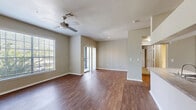 Located in Temple Terrace, FL, this one-bedroom, one-bathroom residence offers a thoughtfully designed layout that maximizes comfort and functionality. The open-concept kitchen and living area serves as the heart of the home, featuring rich wood-style flooring, a peninsula with laminate countertops and a built-in sink, white shaker cabinetry, and stainless steel appliances including a refrigerator and electric range. The living area extends to a private balcony through a sliding glass door framed by vertical blinds, bringing in natural light and outdoor views of the surrounding greenery.

The bedroom is generously proportioned and features plush carpet flooring, a ceiling fan with light, and a large window that fills the room with natural light. A dedicated walk-in closet with wire shelving provides ample storage. The full bathroom is clean and functional, equipped with a tub-shower combination and tile surround.

Additional highlights include a dedicated laundry area with washer/dryer hookups, a separate hallway closet, and consistent neutral-toned walls throughout. The overall ambiance is bright, practical, and well-organized, making this a comfortable and efficient living space.