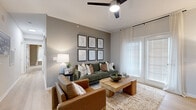 Located at 101 Boone Hall Dr in Piedmont, SC, this single-story residence offers two bedrooms, two bathrooms, and a thoughtfully designed layout across a comfortable footprint. The living room serves as the heart of the home, featuring light hardwood-style flooring, crown molding, a ceiling fan, and large French doors fitted with blinds and sheer curtains that bathe the space in natural light. The kitchen is designed in a galley style with crisp white cabinetry, white countertops, a stainless steel sink, and a full suite of stainless steel appliances, including a refrigerator, range, microwave, and dishwasher. It opens conveniently toward the dedicated laundry room, which houses a full-size front-loading washer and dryer with overhead cabinetry for added storage. The dining area adjoins the main living space and offers a cozy setting with light walls and hardwood-style flooring. The spacious primary bedroom features plush carpeting, a ceiling fan, natural light from a window with blinds, and direct access to a walk-in closet. Both bathrooms are finished with white vanity cabinetry, white countertops, large mirrors, and hardwood-style flooring. Two closets throughout the residence provide ample storage. The overall ambiance is warm, clean, and move-in ready.