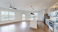 Located on Dublin Blvd in Colorado Springs, CO, this well-appointed 2-bedroom, 2-bathroom residence offers a thoughtfully designed single-floor layout with modern finishes throughout. The open-concept living and kitchen area serves as the heart of the home, anchored by a central island with a built-in sink and striking pendant lighting overhead. Grey cabinetry, stainless steel appliances, and a tile backsplash complete the kitchen, which flows seamlessly into the spacious living area. Warm hardwood-style flooring runs throughout the main living spaces, complemented by crisp white walls that enhance the sense of brightness. Large windows and a glass door flood the living room with natural light while offering scenic views of the surrounding Colorado landscape. A ceiling fan adds comfort to both the living area and bedrooms. The generously sized primary bedroom features plush carpeting, a ceiling fan, and direct access to a private en-suite bathroom, which includes a dual-sink vanity, marble-style shower, and an attached walk-in closet with built-in shelving and hanging rods. The second bedroom, also carpeted, is bright and well-proportioned with convenient closet access. This residence combines clean, contemporary design with functional living spaces in a desirable Colorado Springs location.
