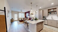 Located at 1951 Integra Dr in West Melbourne, FL, this well-appointed 2-bedroom, 2-bathroom residence offers a thoughtfully designed single-floor layout. The open-concept kitchen and living area serves as the heart of the home, featuring taupe cabinetry, white quartz countertops, a subway tile backsplash, stainless steel appliances, and a center island with pendant lighting — ideal for both cooking and casual dining. The kitchen flows seamlessly into the living room, which is highlighted by wood-look flooring, a bold accent wall, and a ceiling fan. A private balcony accessible from the living area offers scenic views of the surrounding waterfront and lush landscaping. The spacious primary bedroom features plush carpeting, a teal accent wall, generous natural light from large windows, and a dedicated closet. The second bedroom is equally comfortable with its own closet. Both bathrooms are finished with taupe cabinetry, white quartz countertops, and wood-look flooring. Recessed lighting and clean, neutral tones throughout the space create a bright and cohesive aesthetic that balances modern design with everyday functionality.