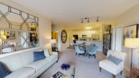 Located at 239 E Broad St in the heart of Greenville, South Carolina, this single-floor residence offers a thoughtfully designed open-concept layout that seamlessly connects the living, dining, and kitchen areas. Neutral-toned carpet flows through the living and bedroom spaces, while wood-look flooring anchors the kitchen and bathrooms, creating a cohesive aesthetic throughout.

The living area is generously proportioned, featuring a sliding glass door that opens to a private balcony with outdoor views, allowing natural light to fill the space. The kitchen is outfitted with crisp white shaker cabinetry, granite-style countertops, a classic tile backsplash, and stainless steel appliances including a range, microwave, and refrigerator. Track lighting and pendant fixtures illuminate both the kitchen and adjoining dining area effectively.

The bedroom is a calm, carpeted retreat with a large window, offering natural light and outdoor views. A walk-in closet provides ample storage. The bathrooms feature tiled tub-shower combinations, with one bathroom offering built-in open shelving for additional storage.

A dedicated in-unit laundry room houses full-sized washer and dryer units, adding everyday convenience to this well-rounded Greenville residence.