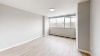 This modern 1-bedroom apartment in Toronto offers a thoughtfully designed living space of 52 square meters. The open-concept layout maximizes the use of space, creating a seamless flow between the living areas. The living room is bright and airy, featuring large windows that flood the space with natural light and provide city views. Light-toned laminate flooring runs throughout, enhancing the sense of spaciousness.

The kitchen, visible from the living area, boasts contemporary white cabinetry and a sleek countertop, perfect for casual dining or entertaining. The bedroom, measuring 15 square meters, offers ample space and includes a closet with sliding doors for efficient storage. The bathroom showcases a clean, modern design with white fixtures and tiled flooring.

Throughout the apartment, neutral wall colors and minimalist design elements create a fresh, inviting atmosphere. The property benefits from recent renovations, evident in its updated fixtures and finishes. Located at 10 Roanoke Rd in Toronto, this single-floor dwelling combines urban convenience with comfortable living, ideal for singles or couples seeking a stylish city home.