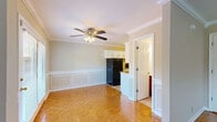 Located at 920 Woodmont Blvd in Nashville's desirable Green Hills neighborhood, this two-story, two-bedroom, two-bathroom unit is thoughtfully laid out across two floors. The main level features a combined kitchen and living area with gleaming parquet wood flooring, crown molding, and ceiling fans throughout. The kitchen is equipped with white cabinetry, granite countertops, a tile backsplash, tile flooring, and black appliances, including a full-size refrigerator and dishwasher. French doors at the end of the kitchen/dining area invite natural light and provide access to the outdoors. The open living area flows naturally from the kitchen, featuring the same warm parquet floors and a staircase leading to the upper level. Upstairs, two carpeted bedrooms each include ceiling fans and ample closet space. The spacious primary bedroom offers a generous footprint, while the second bedroom features a double closet and a wall-mounted HVAC unit. Both bathrooms are finished in neutral tones; one features a tiled tub/shower combination with chrome fixtures, and the other includes a dual-sink vanity. A dedicated laundry area with an in-unit washer completes this practical and well-appointed home.