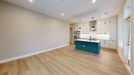 Located in Decatur, GA, this thoughtfully designed 3-bedroom, 2-bathroom unit offers a comfortable and modern living experience across a single floor. The open-concept kitchen and living area serves as the heart of the home, showcasing light wood-style flooring, recessed lighting, and a striking teal kitchen island with a white quartz countertop. White shaker cabinetry with matte black hardware, a stainless steel refrigerator, built-in microwave, and a wall-mounted range hood complete the kitchen's contemporary aesthetic. A window overlooking greenery brings natural light into the space.

The primary bedroom is generously sized and features plush carpeting, a ceiling fan, and direct access to a walk-in closet with built-in shelving and hanging rods. The additional bedrooms are equally comfortable, each with soft carpet, ceiling fans, and ample natural light from multiple windows with views of surrounding trees. Both walk-in closets are well-organized with tiered shelving systems.

The bathrooms are elegantly finished with large-format marble-look tile flooring, white vanities with chrome fixtures, dark-framed mirrors, and matte black hardware accents. The unit's neutral gray palette and clean architectural lines create a cohesive, modern ambiance throughout.