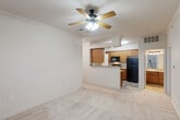 Located at 2118 W Old Spanish Trail in New Iberia, Louisiana, this two-story home offers a practical and well-organized layout spread across two levels. The main living area on the upper floor features a combined dining and living room with neutral carpet flooring, crown molding, and a ceiling fan with light fixture, creating a comfortable and airy atmosphere. Natural light filters in through windows fitted with blinds, enhancing the brightness of the space. The living area opens toward the kitchen, which is equipped with warm-toned wooden cabinetry, granite-style countertops, a peninsula with a sink, and black appliances including a refrigerator, range, and over-the-range microwave. Tile flooring grounds the kitchen space. The bedroom is a well-proportioned room featuring plush carpet, a ceiling fan, and a window that brings in natural light. A dedicated closet provides ample storage. The full bathroom includes a tub/shower combination, a wooden vanity cabinet with granite-style countertop, tile flooring, and additional overhead cabinetry. A separate laundry room with wire shelving and washer/dryer hookups adds everyday convenience. A bonus room and carpeted staircase connecting both floors complete this efficiently designed home.
