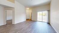 Located in Mesa, AZ, this 2-bedroom, 2-bathroom single-level residence offers a thoughtfully designed floor plan with modern finishes throughout. The open living area features tall ceilings, wood-look luxury vinyl flooring, and a sliding glass door that fills the space with natural light and provides outdoor access. The kitchen is well-appointed with warm wood-tone cabinetry, light quartz countertops, stainless steel appliances including a refrigerator, range, microwave, and dishwasher, along with ample storage and counter space. The spacious primary bedroom includes its own en-suite bathroom featuring a single-sink vanity with wood cabinetry, quartz countertop, and a walk-in shower. The second bathroom offers a similar vanity design paired with a full shower-tub combo. Both bedrooms are generously sized with wood-look flooring and windows providing natural light. A dedicated laundry room houses an in-unit washer and water heater for added convenience. Clean white walls, consistent flooring, and a neutral palette create a cohesive, modern ambiance throughout this well-organized Mesa residence.