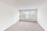Located at 13430 Coppermine Rd in Herndon, VA, this 2-bedroom, 2-bathroom unit offers a thoughtfully designed single-floor layout. The kitchen is a standout feature, boasting white shaker cabinetry, granite-look countertops, and a full suite of stainless steel appliances including a dishwasher, range, and refrigerator. Light wood-style flooring runs through the kitchen and living areas, while a peninsula counter opens toward the carpeted living space, creating a seamless, connected feel. Both bedrooms are comfortably sized, with the primary bedroom offering generous proportions, a dedicated closet, and a private en-suite bathroom. Natural light filters in through windows with views of surrounding greenery, lending a calm, airy ambiance to both rooms. The primary bathroom features a walk-in shower equipped with accessibility grab bars and clean white tile, while the second bathroom offers a tub-shower combination with a white vanity and wood-style flooring. A hallway connects the bedrooms to their respective bathrooms, providing a functional and private layout. Neutral tones throughout the unit create a bright, welcoming atmosphere well-suited to a variety of living arrangements.