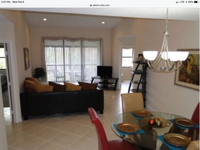 Sala de estar y comedor con iluminación empotrada, techo abovedado y vista al estanque. - 5265 Brisata Circle