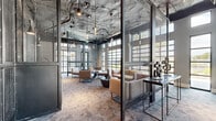 Located at 5 Resort Dr in Savannah, Georgia, this single-floor amenity facility offers a generously sized, thoughtfully designed space that blends industrial aesthetics with modern sophistication. The exposed ceilings reveal ductwork and structural elements finished in dark tones, complemented by pendant lighting that creates a warm, dynamic atmosphere throughout.

The fitness area is extensive and well-appointed, featuring a wide array of strength training equipment including cable machines, power racks, and a full dumbbell rack. A dedicated cardio zone houses multiple treadmills and an elliptical, while a separate studio space is equipped with cycling bikes, a ballet barre, exercise balls, and a mounted flat-screen display — ideal for group classes or individual training sessions. Floor-to-ceiling mirrors amplify the sense of space across the gym floor.

Adjacent to the fitness areas, a contemporary lounge space provides a welcoming retreat. Sleek metal mesh partitions divide the seating zones while maintaining visual openness. Modern low-profile furniture in neutral tones is arranged for social interaction, surrounded by large windows that invite abundant natural light and views of the surrounding landscape. Patterned carpet flooring flows cohesively throughout, tying the industrial and refined design elements together seamlessly.