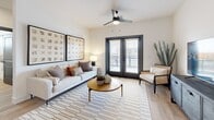 Located in Mesa, Arizona, this thoughtfully designed 3-bedroom, 3-bathroom residence offers a contemporary open-concept layout with upscale finishes throughout. The kitchen serves as a central hub, featuring dark flat-panel cabinetry, stainless steel appliances, quartz countertops, and a spacious island with seating for three — illuminated by sleek pendant lighting. Light wood-style flooring flows seamlessly through the main living areas, complementing the clean white walls and modern aesthetic. A built-in desk nook provides a dedicated workspace just off the kitchen. The living room is bright and inviting, with a ceiling fan, large French doors that open to an outdoor balcony, and an abundance of natural light. Each of the three bedrooms is carpeted for comfort and includes a ceiling fan and natural light from well-placed windows. The primary bedroom connects to a well-appointed bathroom and a walk-in closet with built-in shelving. The bathrooms are finished with tile-surround walk-in showers, quartz vanities, and dark-framed fixtures, maintaining the home's cohesive modern palette. Overall, the space strikes a balance between functional design and refined style, ideal for comfortable everyday living.