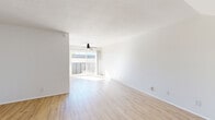 Located at 6363 Beadnell Way in San Diego, CA, this two-story, 2-bedroom, 3-bathroom home offers a bright and clean aesthetic throughout. The main level opens into a spacious living area bathed in natural light, featuring light wood-tone flooring, crisp white walls, a textured ceiling, and a ceiling fan. Large sliding glass doors lead to a private balcony, enhancing the airy feel of the space. The kitchen is well-appointed with white cabinetry, light countertops, black appliances including a refrigerator, wall oven, microwave, and dishwasher, complemented by a matte black sink fixture and a skylight overhead. A combined dining and kitchen area flows naturally into the living room, making the lower level ideal for everyday living and entertaining. The upper level hosts both bedrooms, each carpeted for comfort and filled with natural light from well-placed windows. The primary bedroom is generously sized and features multiple closets, providing ample storage. A secondary bedroom includes built-in shelving and an additional closet. Three full bathrooms, including one with a tub-shower combination, serve the home. With five total closets and a convenient staircase connecting both floors, this home balances practicality with a clean, modern design in a sunny San Diego setting.