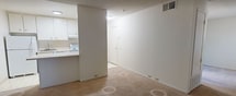 Located at 511 Q St in Sacramento's vibrant Midtown neighborhood, this 450-square-foot, one-bedroom, one-bathroom apartment is thoughtfully laid out across a single floor. The living area features neutral-toned carpet and white walls beneath a textured ceiling, creating a clean and bright atmosphere. A large window with vertical blinds allows natural light to fill the space while offering views of outdoor greenery. The semi-open kitchen is positioned adjacent to the living area, separated by a peninsula counter. It includes white cabinetry, an under-cabinet range hood, a sink, and essential appliances, all illuminated by overhead lighting. A hallway connects the main living space to the private bedroom and bathroom. The bedroom, measuring approximately 410 square feet, is carpeted and features a sliding-door closet with double hanging rods, offering ample storage. The bathroom is efficiently designed with a combined tub and shower enclosed by frosted sliding glass doors, a toilet, and light tile flooring. HVAC vents are present throughout the unit, ensuring year-round climate control. This apartment is well-suited for individuals seeking a manageable, low-maintenance living space in a central Sacramento location.