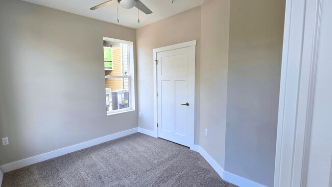 Habitación alfombrada con ventilador de techo en un apartamento disponible en Greenwood Commons Apartments en Delaware, Ohio. - Greenwood Commons Apartments