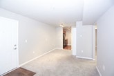 This single-story residence offers a practical and well-organized layout designed for comfortable everyday living. The entry opens into a spacious living area finished with plush carpet and wood-look hardwood flooring at the threshold, providing a warm transition into the home. Track lighting illuminates the path toward the kitchen, which features warm wood cabinetry, granite-style laminate countertops, a double stainless steel sink, and a black dishwasher. Upper and lower cabinet storage provides ample organization space.

The bedrooms are carpeted and bathed in neutral gray tones, each equipped with ceiling fans for year-round comfort. Several bedrooms include sliding-door closets with built-in shelving, and windows dressed with horizontal blinds allow natural light to filter in. One bedroom features a tray ceiling detail, adding a subtle architectural touch.

The two bathrooms are finished with wood-look vinyl plank flooring for durability. One bathroom includes a walk-in shower stall with a clean white surround, while the other offers a shower-tub combination. Both feature wood-toned vanities with stone-style countertops. The overall color palette throughout the unit is cohesive and understated, creating a calm, move-in-ready atmosphere.