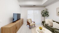 Located at 50 Otterbein Rd in Kitchener, Ontario, this thoughtfully designed one-bedroom, one-bathroom unit offers a clean, modern aesthetic throughout. The open-concept kitchen and living area forms the heart of the home, featuring a sleek white cabinetry kitchen with a peninsula breakfast bar, quartz-style countertops, and stainless steel appliances including a refrigerator, electric range, and over-the-range microwave. Light wood-tone flooring flows seamlessly through the main living spaces, complementing the bright white walls and recessed lighting. The living room is a comfortable and well-lit space with a large sliding window that brings in natural light and connects the interior to the outdoors. The bedroom is a well-proportioned retreat featuring a tray ceiling, mirrored sliding closet doors, and a window with a roller shade for privacy. The full bathroom offers a clean, spa-like feel with marble-look tile flooring and a full soaker tub with shower. A dedicated in-suite laundry room with a full-size washer and dryer, built-in shelving, and marble-look tile adds exceptional convenience. The overall ambiance is light, airy, and modern — a polished space designed for everyday comfort.
