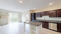 Located at 2290 Anchor Dr in North St. Paul, MN, this well-appointed two-bedroom, two-bathroom residence offers a thoughtfully designed single-level layout. The open-concept kitchen and living area serves as the heart of the home, showcasing rich dark-espresso cabinetry, granite countertops, and a full suite of stainless steel appliances including a range, microwave, and French door refrigerator. A freestanding kitchen island with additional granite surface and built-in shelving provides extra workspace and storage. Light hardwood-style flooring runs throughout the main living areas, complementing the neutral color palette and recessed lighting. The living room benefits from natural light and direct access to a private balcony overlooking a lush, tree-lined setting. Both bedrooms are carpeted and feature large windows with wooded views, ceiling fans, and baseboard heating. The primary bedroom is generously proportioned with its own dedicated closet. The primary bathroom features a double-sink granite vanity with dark cabinetry, while the second bathroom includes a full tub and shower combination. A dedicated in-unit laundry room with side-by-side washer and dryer and overhead shelving adds everyday convenience. Two closets provide ample storage throughout.