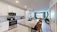 Located in Tampa, FL, this well-appointed 2-bedroom, 2-bathroom single-story home offers a thoughtfully designed open-concept layout. The kitchen is a standout feature, showcasing crisp white shaker cabinetry, granite countertops, stainless steel appliances, and a large center island with pendant lighting and bar seating — ideal for both cooking and entertaining. The kitchen flows seamlessly into the bright living room, which features light wood-look flooring, a ceiling fan, and large windows that invite natural light. The primary bedroom is generously sized, complete with soft carpet flooring, a calming blue accent wall, and a walk-in closet with built-in shelving. The en-suite primary bathroom offers a double-sink vanity with granite countertops, white cabinetry, large-format tile flooring, and a glass-enclosed shower. The second bedroom mirrors the cozy aesthetic with matching carpet and accent wall tones. Throughout the home, six closets provide exceptional storage. A private patio extends the living space outdoors. With a neutral color palette, modern fixtures, and a cohesive design throughout, this home delivers comfort and style in equal measure.
