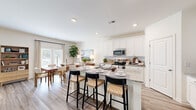 This well-appointed two-story home in Mountain Park, Georgia offers a thoughtfully designed layout across two floors. The main level features an open-concept living area where the kitchen, dining room, and living room flow seamlessly together. The kitchen is a standout, boasting white shaker cabinetry, granite countertops, stainless steel appliances, and a central island with seating for three — ideal for casual dining and entertaining. Recessed lighting and light wood-tone flooring enhance the bright, airy atmosphere throughout the main floor. The dining area benefits from large windows that invite natural light, while the living room features a ceiling fan and additional windows that add to the comfortable ambiance. A bathroom on the main level provides added convenience. Upstairs, the generously sized primary bedroom features plush carpeting, a ceiling fan, and ample natural light from a large window. It is complemented by a spacious walk-in closet with built-in shelving. Three additional bedrooms and two more full bathrooms complete the upper level, offering versatile space for family or guests. Two closets and multiple hallways ensure practical storage throughout. This home combines modern finishes with a functional, inviting layout suited for everyday living.