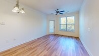 Located in Charlotte, NC, this single-floor, one-bedroom, one-bathroom residence offers a well-organized and efficiently designed layout. Hardwood-style flooring flows consistently throughout, lending a cohesive and clean aesthetic to every room.

The living room is a bright, welcoming space featuring crown molding, a ceiling fan, and large windows that frame lush outdoor greenery. A glass-panel door provides direct access to an exterior balcony, further enhancing the sense of openness and natural light.

The kitchen is functionally equipped with warm wood cabinetry, granite-style countertops, and black appliances including a refrigerator, electric range, microwave, and dishwasher. The layout maximizes efficiency within the space and connects seamlessly to the rest of the unit via a hallway.

The bedroom is a comfortably sized room with a ceiling fan, a window overlooking greenery, and access to a dedicated closet, providing practical storage. Crown molding adds a refined detail to the space.

The bathroom features a soaking tub with a tiled surround in warm earth tones, a vanity with granite-style countertops, and hardwood-style flooring that matches the rest of the home. The overall ambiance is clean, neutral, and move-in ready.