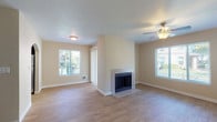 This single-floor residence offers a thoughtfully designed layout with a comfortable and functional feel throughout. The living area serves as the focal point of the space, featuring light wood-look flooring, a ceiling fan with lighting, and a tile-surround fireplace that adds warmth and character. Multiple windows allow natural light to fill the room while providing views of surrounding greenery, creating a bright and welcoming atmosphere.

The layout connects the living area to an entry hall, where in-unit laundry is conveniently accessible and an arched transition leads toward the kitchen. The kitchen is equipped with rich, dark wood cabinetry, light-toned countertops, a stainless steel dishwasher, and a double sink beneath a window, offering both style and practicality.

The bedroom features plush carpeting, a baseboard heater, and a window overlooking the outdoors, providing a quiet retreat. The bathroom includes a vanity with dark cabinetry and a wide mirror, alongside a walk-in closet fitted with wire shelving for ample storage. An additional full bathroom with a soaking tub completes the space. Neutral warm-toned walls throughout lend a cohesive, move-in-ready aesthetic.