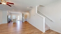 Located at 707 E Second Ave SW in Rome, GA, this three-story home offers four bedrooms, three bathrooms, and a thoughtfully organized layout spread across multiple levels. The ground floor houses an attached two-car garage with an automatic opener and concrete flooring, providing ample parking and storage. The main level features an open-concept kitchen and living area with warm wood-look flooring throughout. The kitchen is a standout, showcasing gray shaker-style cabinetry, granite countertops, a center island with a built-in sink, recessed lighting, and multiple windows that invite abundant natural light. A dedicated laundry room on this level includes a full-size washer and dryer with overhead wire shelving. The upper floor is home to four carpeted bedrooms, each fitted with ceiling fans and windows with blinds. The primary bedroom includes a walk-in closet outfitted with wire shelving. Three bathrooms serve the home, featuring granite-topped vanities and gray cabinetry; one bath offers a glass-enclosed walk-in shower with wood-look flooring, while another includes a full tub-shower combo. Clean white walls, consistent finishes, and a neutral palette create a bright, cohesive ambiance throughout the home.
