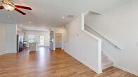 Located at 707 E Second Ave SW in Rome, GA, this three-story, 4-bedroom, 4-bathroom home offers a well-organized layout spread across three distinct levels. The ground floor houses an attached garage with an automatic opener, providing convenient enclosed parking and additional storage space. The main living level features an open-concept design connecting the living room and dining area, with warm hardwood-style flooring flowing throughout. The kitchen is a standout, boasting a central island with a granite countertop and undermount sink, gray shaker-style cabinetry, recessed lighting, and multiple windows that fill the space with natural light. A dedicated laundry area with a full-size washer and dryer is conveniently located on this level. Carpeted staircases with clean white railings connect all three floors. The upper level hosts the bedrooms, including a primary suite with its own closet featuring wire shelving. All four bathrooms are finished with granite vanities, gray cabinetry, and hardwood-style flooring; the primary bath includes a glass-enclosed walk-in shower. With seven closets total and a patio for outdoor enjoyment, this home delivers practical storage and comfortable living throughout.