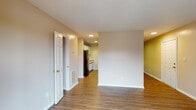 Located at 2613 Whitaker Dr in Greenville, North Carolina, this single-floor home offers a practical and comfortable layout with consistent wood-look flooring carried throughout every room. The open living and dining area forms the heart of the home, with neutral beige walls, a textured ceiling, and recessed lighting that creates a bright, welcoming atmosphere. A sliding glass door in the main living space provides direct access to an outdoor patio with lattice detail, allowing natural light to fill the room. The galley-style kitchen features dark granite-look countertops, white cabinetry with wood-trimmed accents, and black appliances including an electric range and refrigerator, all set on a durable wood-look floor. The bedrooms are well-proportioned, each featuring ceiling fans with light fixtures, wood-look flooring, and ample natural light from blinds-fitted windows. At least one bedroom includes a reach-in closet with built-in shelving. The bathroom is finished with a dark speckled granite vanity top, a large mirror with overhead lighting, and a tub-shower combination. Clean white trim and doors are consistent throughout, lending the space a cohesive and well-maintained appearance.