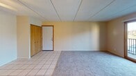 Located at 170 Briargate Rd in Mankato, Minnesota, this single-floor unit offers a practical and well-organized layout. The entryway opens into a combined living and dining area finished with light ceramic tile flooring, a ceiling fan, and a closet with warm oak-toned bi-fold doors. The space transitions into carpeted areas that extend through the bedrooms, providing a comfortable feel underfoot.

The galley-style kitchen is efficiently designed with ample warm wood cabinetry on both sides, dark granite-look countertops, a gas range, refrigerator, dishwasher, and a double stainless steel sink, all set atop clean tile flooring. The layout maximizes storage and workspace within a compact footprint.

The bedrooms are carpeted and neutrally painted, with one room featuring a window that overlooks the surrounding outdoor scenery, allowing natural light to fill the space. Additional rooms offer versatility for use as a bedroom, office, or flex space.

The bathroom includes a full tub-shower combination, a toilet, a vanity with storage, and a mirror medicine cabinet, all finished with tile flooring and clean, neutral tones throughout.

Consistent beige tones, textured drop ceilings, and wood-framed door trim unify the space, creating a cohesive and functional living environment suitable for everyday comfort.