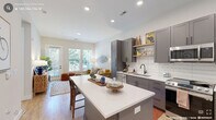 Located in Morrisville, NC, this thoughtfully designed one-bedroom, one-bathroom residence offers a functional and modern living experience across a single floor. The open-concept kitchen and living area serves as the heart of the home, where the two spaces flow seamlessly together. The kitchen is outfitted with gray shaker-style cabinetry, stainless steel appliances including a range, microwave, dishwasher, and refrigerator, white subway tile backsplash, and a large central island with white countertops that doubles as a dining and prep space. Light wood flooring runs throughout, adding warmth to the clean, neutral palette. The living area benefits from generous natural light streaming through large windows and a glass door that opens to a private balcony with outdoor views. The bedroom is a calm, well-proportioned retreat featuring tall ceilings, additional windows for natural light, and direct access to a dedicated closet. The bathroom features gray vanity cabinetry that coordinates with the kitchen, a framed mirror, modern light fixtures, and a walk-in shower. A hallway connects the spaces efficiently, completing this cohesive and practical layout ideal for modern living.