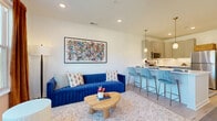 Located at 8770 Galaxy Way in Columbus, OH, this thoughtfully designed one-bedroom, one-bathroom residence offers a well-utilized single-floor layout with modern finishes and a bright, welcoming ambiance. The open-concept living and kitchen area forms the heart of the home, featuring light wood-style flooring, recessed lighting, and large windows that flood the space with natural light and frame serene outdoor views of greenery. The kitchen is well-appointed with grey shaker-style cabinetry, stainless steel appliances including a refrigerator, range, microwave, and dishwasher, a undermount sink, light countertops, and a peninsula with seating — ideal for casual dining or entertaining. A wide hallway connects the main living area to the private bedroom, which benefits from large windows with outdoor views and direct access to a private balcony. The bathroom includes a vanity with ample cabinet storage, a tub-shower combination, and matching wood-style flooring. Two closets provide generous storage, while a dedicated laundry area and utility room add practical convenience. The clean white walls, contemporary fixtures, and cohesive design palette create a polished, modern atmosphere throughout this efficiently organized residence.