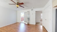 This single-floor residence offers a clean, practical layout with consistent finishes throughout. The main living area is bright and open, featuring warm hardwood-style flooring, crisp white walls, and a textured ceiling with a ceiling fan that provides both comfort and light. Natural light filters in through windows fitted with horizontal blinds, and a glass-paneled front door opens to an exterior view, enhancing the sense of openness. The living space connects to additional rooms, offering a straightforward and functional floor plan.

The kitchen is efficiently arranged with light-toned cabinetry providing ample storage, a matching set of black appliances including a full-size refrigerator and range, and the same hardwood-style flooring that flows throughout the common areas. The bathroom features a single-sink vanity with a stone-look countertop, cream cabinetry, and a full tub-shower combination with clean white surrounds.

The bedroom is carpeted for comfort and includes a dedicated walk-in closet with a built-in shelf and hanging rod, offering practical storage. A window allows natural light into the room, and a ceiling fan adds to the functional comfort of the space. Overall, the residence presents a tidy, move-in ready interior with consistent, neutral finishes.
