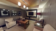 This elegantly appointed single-floor space exudes a refined hospitality ambiance, thoughtfully designed for comfort and style. The ceiling is a standout architectural feature, showcasing a warm slatted wood design accented by recessed lighting panels and a row of modern pendant lights that cast a soft, inviting glow throughout the room. The walls are finished in a muted taupe tone, providing a neutral backdrop that complements the rich wood and upholstered furnishings. A large wall-mounted flat-screen television is set within a bold, oversized dark frame, serving as the focal point of the main seating area. Flanking the TV are framed black-and-white wall art pieces that add a touch of contemporary sophistication. The seating arrangement features plush, neutral-toned lounge chairs positioned around a substantial wood-grain coffee table, creating an intimate and functional gathering space. A secondary accent table with a dark glass top is positioned nearby, accompanied by a stylish red-shaded lamp that introduces a subtle pop of color. The carpeted floor adds warmth underfoot, while the overall layout maximizes the sense of space. The cohesive design blends modern and transitional elements, making this a polished and welcoming environment suited for relaxation or private gatherings.