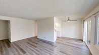 Located at 200 Orchard Pl in Oxnard, CA, this single-floor, one-bedroom, two-bathroom residence offers a clean, contemporary interior with a neutral color palette throughout. The open living and dining area is finished with durable wood-look plank flooring, a textured ceiling, and a ceiling fan, creating a bright and comfortable gathering space. Large sliding glass doors lead to a private balcony, filling the room with natural light and providing outdoor views.

The galley-style kitchen is outfitted with white shaker cabinetry, white quartz countertops, a stainless steel sink, and a gas range, all illuminated by recessed lighting. Wood-look flooring continues seamlessly through the kitchen, maintaining a cohesive aesthetic.

The bedroom is generously sized for the footprint of the home, featuring soft carpeting, a window with natural light, mirrored sliding closet doors, and direct access to one of the two bathrooms. The bathrooms are clean and functional, with one featuring a tub/shower combination with chrome fixtures.

A dedicated entrance and a connecting hallway provide logical flow between rooms. The overall ambiance is fresh and move-in ready, with consistent finishes and a bright, airy feel throughout the entire space.