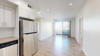 Located at 744 Hartford Ave in Los Angeles, CA, this thoughtfully designed 2-bedroom, 2-bathroom unit offers a clean, modern aesthetic throughout its efficiently laid-out single floor. Light wood-look flooring runs continuously through all rooms, creating a cohesive and bright atmosphere complemented by crisp white walls and recessed lighting.

The kitchen is well-appointed with white shaker-style cabinetry, a white tile backsplash, quartz-style countertops, and a full suite of stainless steel appliances including a gas range, microwave, dishwasher, and refrigerator. It opens toward the living area, which is bathed in natural light and features sliding glass doors leading to a private balcony with outdoor views of the surrounding neighborhood and palm trees.

Both bedrooms are generously proportioned with large windows or sliding glass balcony doors that invite abundant natural light. The primary bedroom includes a dedicated walk-in closet outfitted with built-in shelving and a clothing rod. A connecting hallway links the bedrooms to the two bathrooms, one of which features a wood-toned vanity with under-sink storage, a large mirror, and modern fixtures. The layout is completed by a dedicated hallway and additional closet space, ensuring practical storage throughout.
