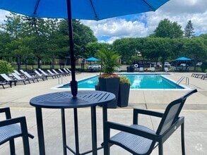 Relaxing Swimming pool with lounge seating at Lakeside Village Apartments in Clinton Township, MI - Lakeside Village Apartments
