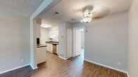 Located at 1715 Theater Dr in Evansville, Indiana, this single-floor residence offers a thoughtfully designed layout with a clean, neutral aesthetic throughout. The galley-style kitchen is a standout feature, equipped with white shaker cabinetry, dark countertops, a tile backsplash, and stainless steel appliances including a dishwasher, electric range, and refrigerator — providing a functional and stylish cooking environment. The open living and dining areas are finished with durable hardwood-style flooring and textured ceilings, creating a bright and welcoming atmosphere. A ceiling fan adds comfort to the main living space, which also benefits from a large window that lets in natural light. The bedroom features its own ceiling fan, a built-in closet, and the same hardwood-style flooring found throughout the unit. The bathroom is clean and practical, offering a full tub-shower combination. A dedicated in-unit laundry area accommodates a stacked washer and dryer, adding everyday convenience. The entry area provides a welcoming transition into the living space. Consistent finishes and a neutral color palette give the entire residence a cohesive, move-in-ready feel.